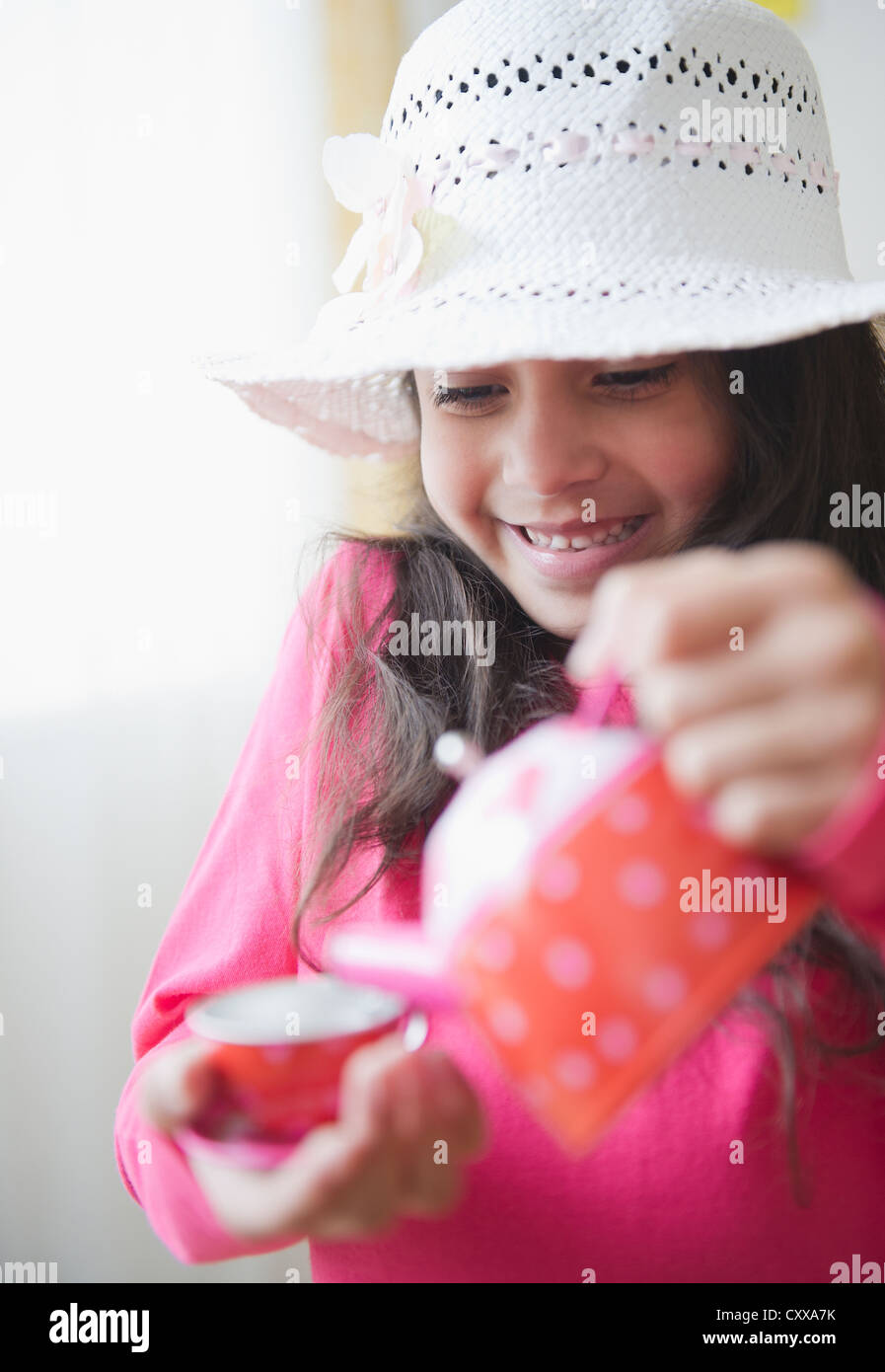 Razza mista ragazza versando il tè Foto Stock