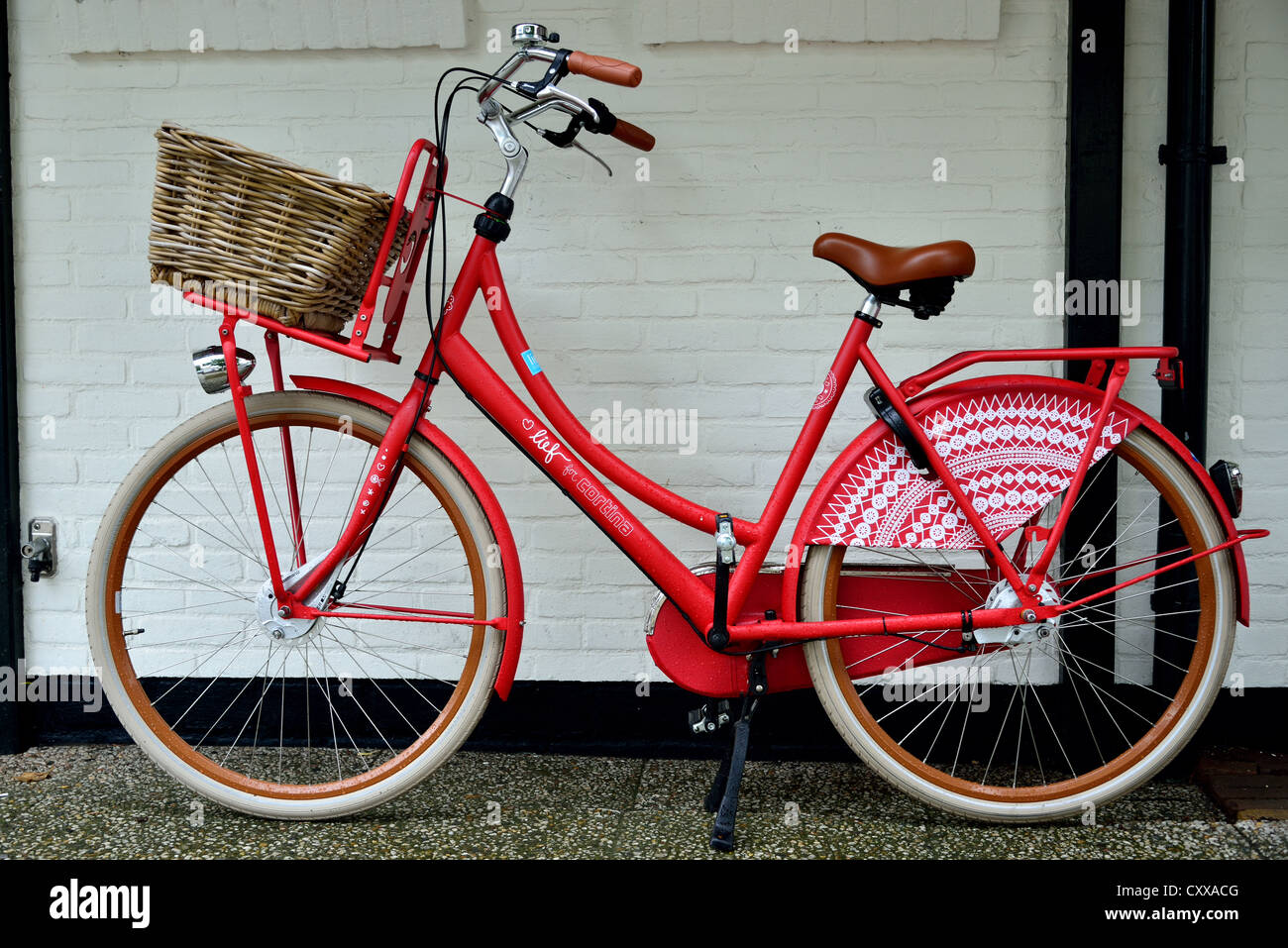 Uno stile tradizionale ragazza in bicicletta con cestello. Foto Stock