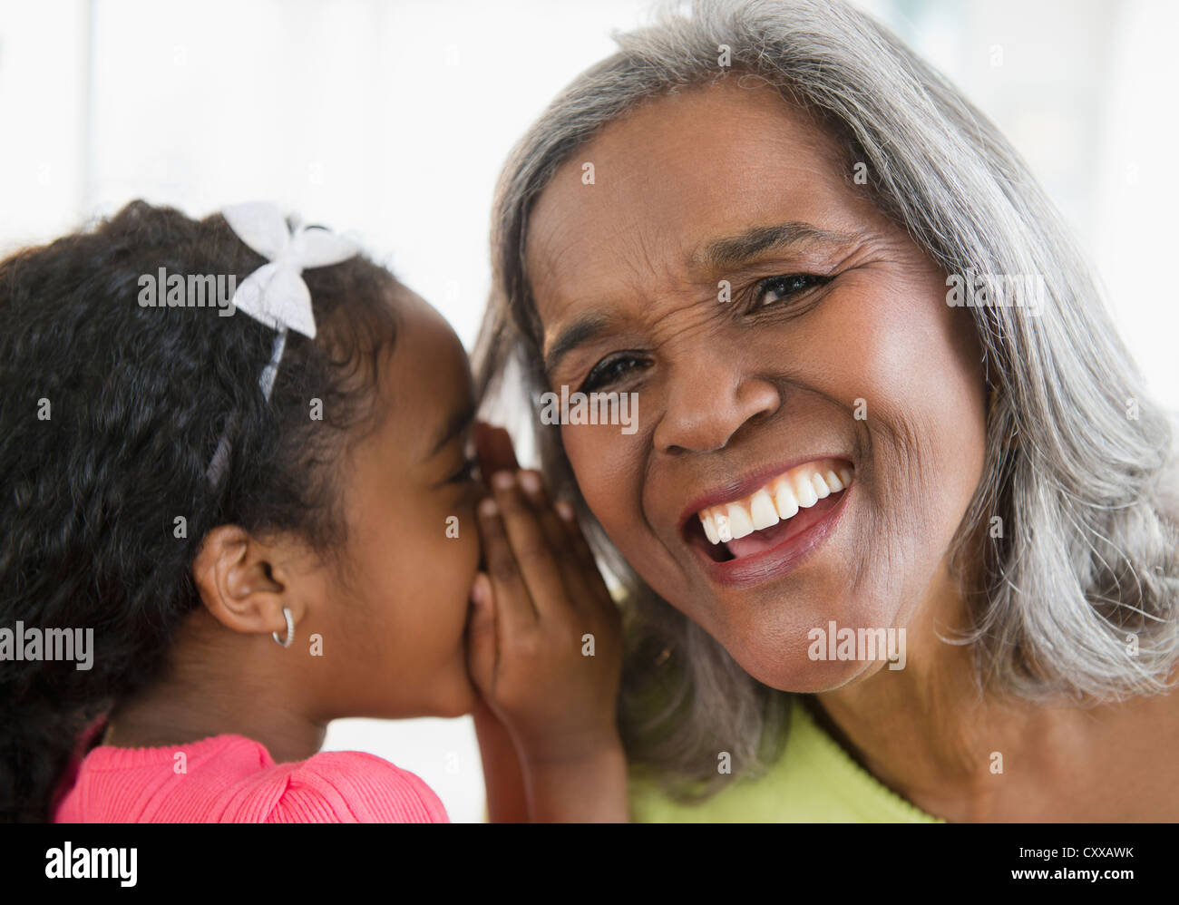 African American Girl raccontare segreto di nonna Foto Stock