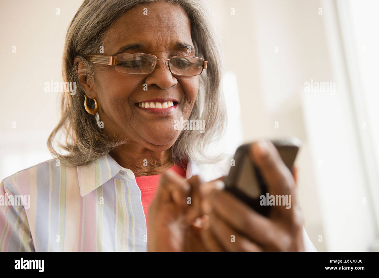 African American donna tramite telefono cellulare Foto Stock