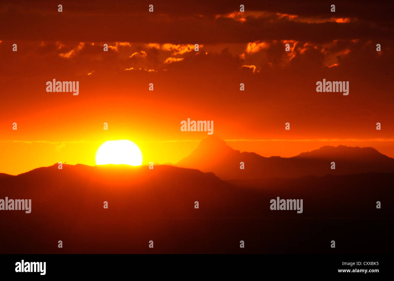 Il sole illumina Baboquivari picco, (in distanza sulla sinistra) , situato a 50 miglia a sud-ovest di Tucson, Arizona, Stati Uniti. Foto Stock