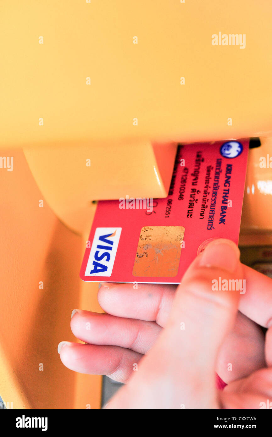 Mano femmina inserisce una tessera in materia plastica nell'ATM Foto Stock