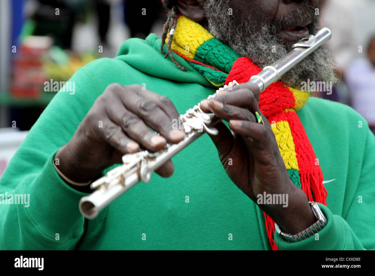 L'uomo del musicista Rastafariano Dreadlocks suona il flauto sulla strada a Londra Foto Stock