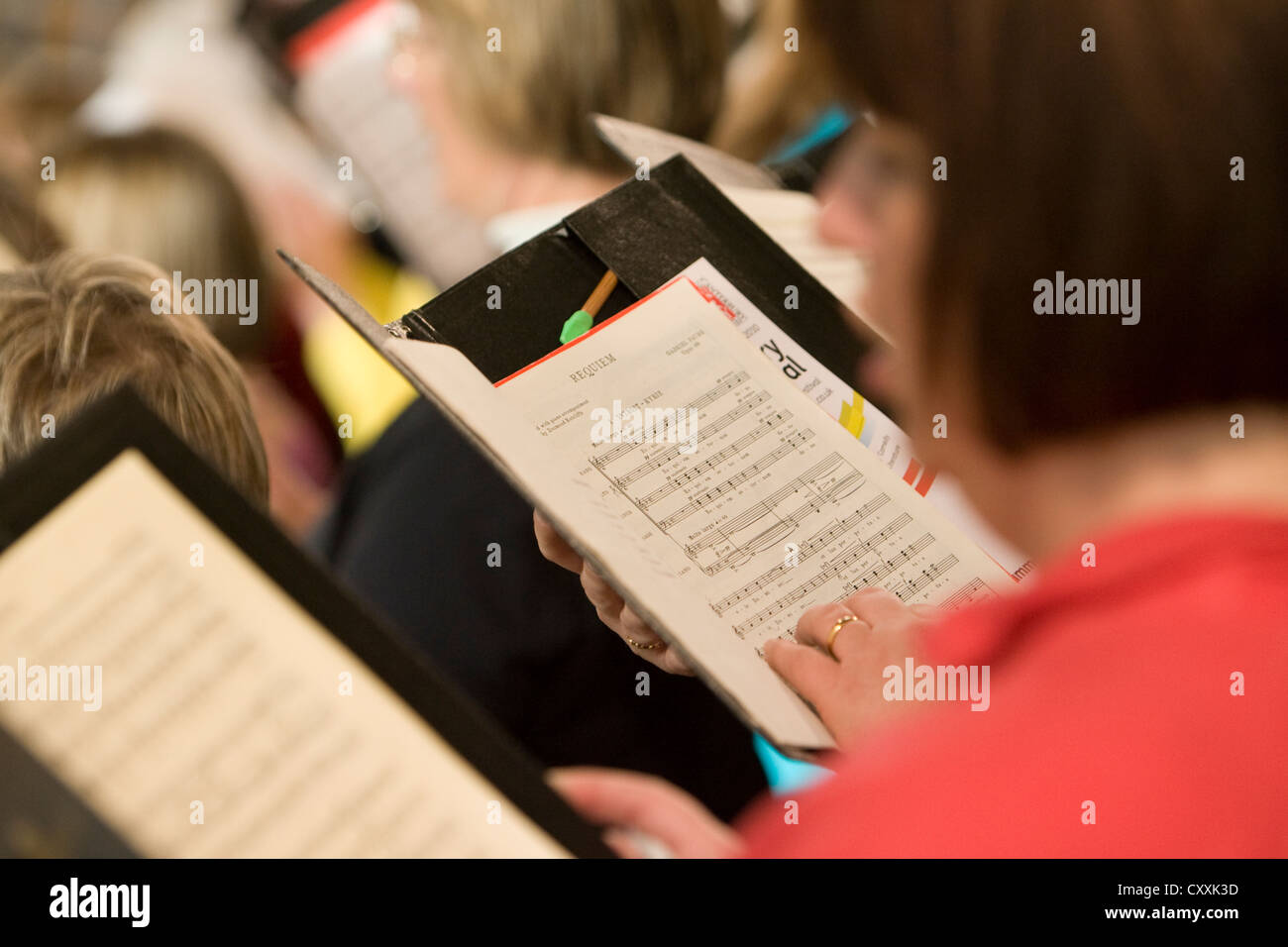 Membri del coro di canto e di esercitarsi utilizzando fogli di musica, Festival di Canterbury Foto Stock