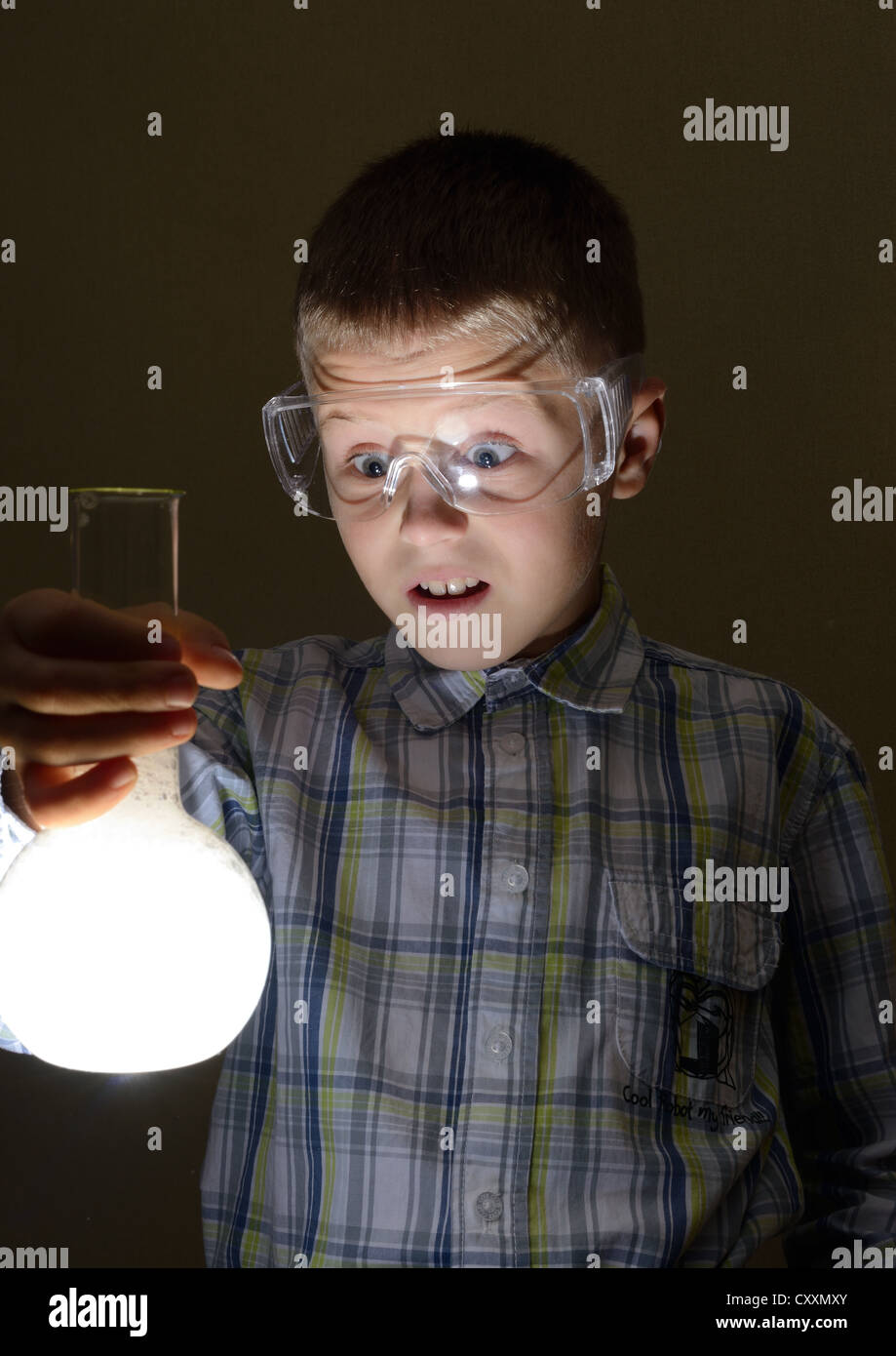Scolaro holding lampadina incandescente Foto Stock