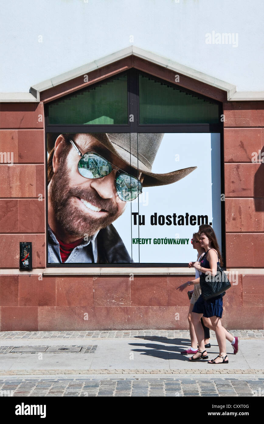 Passeggini a piedi da "ho qui il Credito in contanti immediatamente,' poster con l'attore Chuck Norris pubblicità per Bank Zachodni WBK a Wroclaw in Polonia Foto Stock