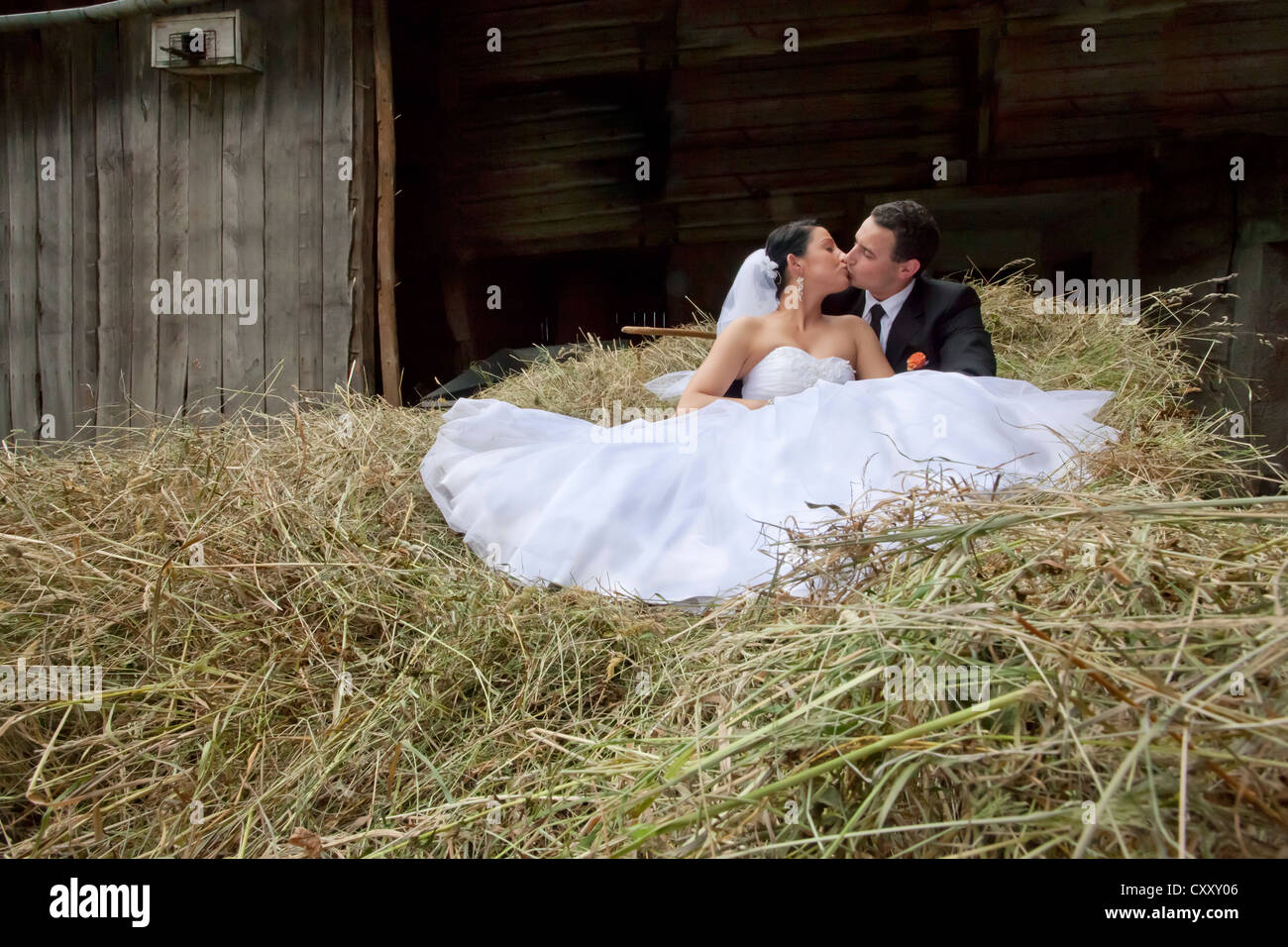 Sposa e lo sposo, sposi seduti sul fieno fieno sparso, granaio Foto Stock