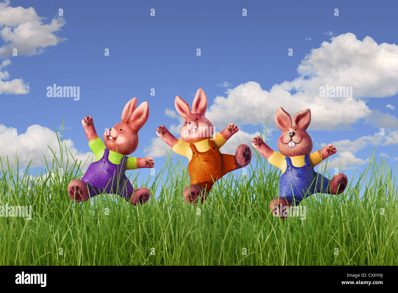 Tre conigli pasquali jumping in un prato, illustrazione Foto Stock