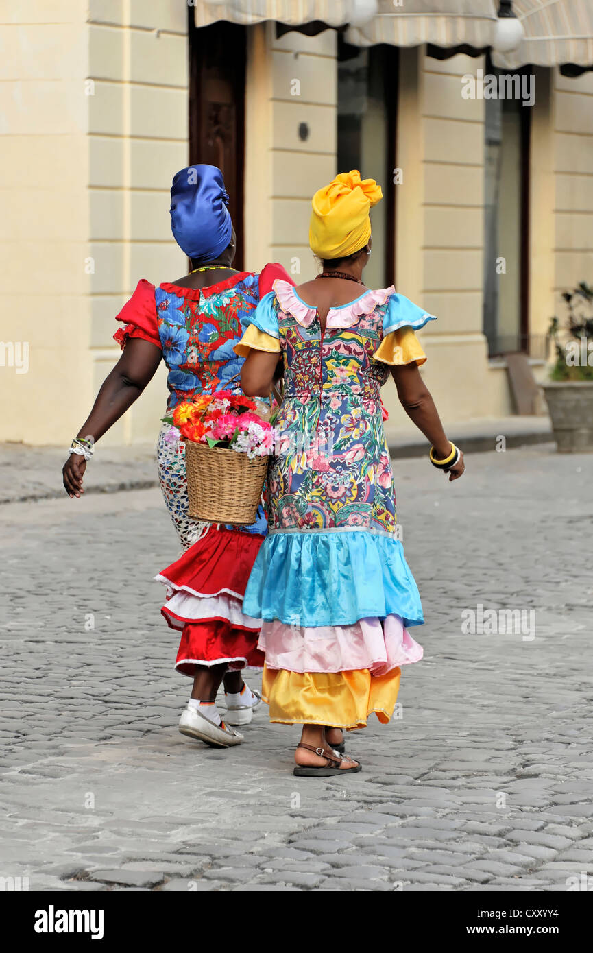 Due donne Creole indossando abiti colorati a piedi nel centro di Avana, Cuba, Antille Maggiori, America Centrale, America Foto Stock