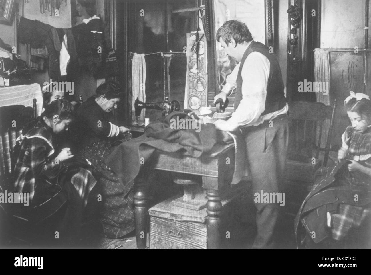 Famiglia lavorando su capi di abbigliamento in Tenement Appartamento, New York City, Stati Uniti d'America, circa 1906 Foto Stock