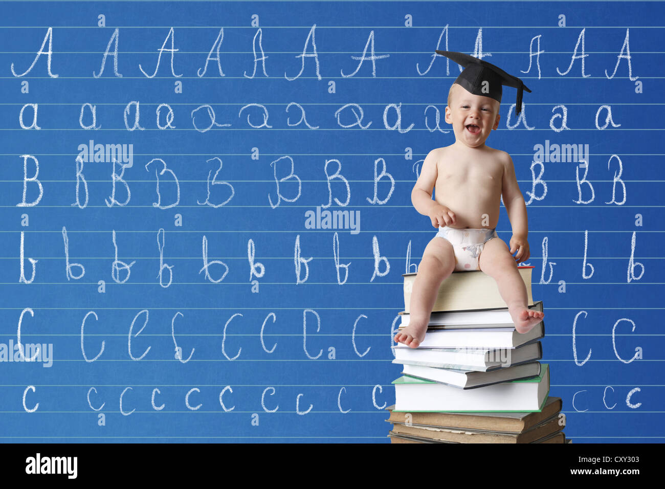 Infant indossando un cappello di graduazione seduto su una pila di libri di fronte a una scuola lavagna con l ABC Foto Stock