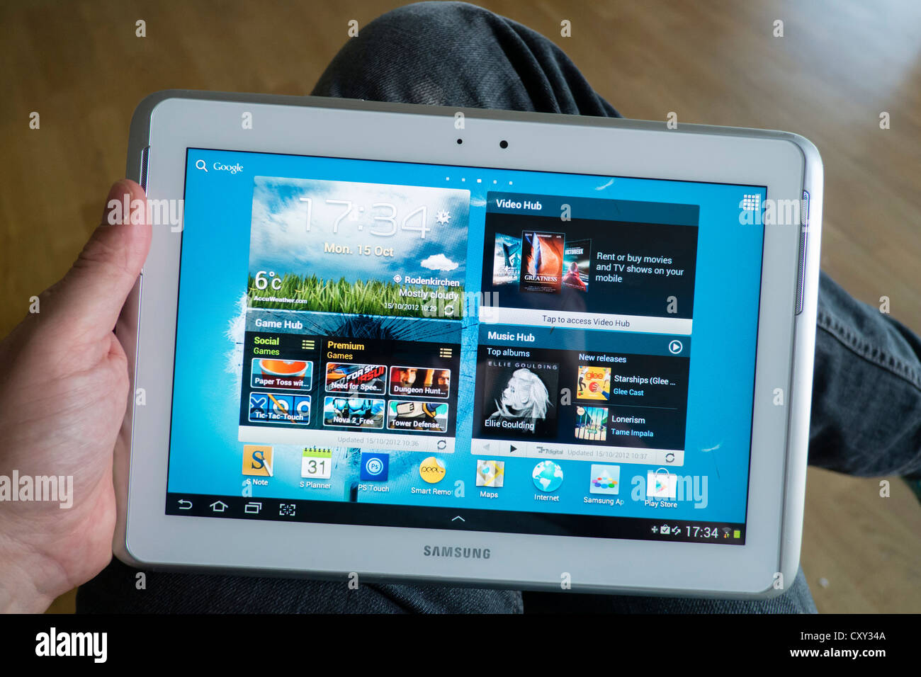 Uomo con Samsung Galaxy nota 10.1 tablet computer su cui è in esecuzione il sistema operativo Android e mostrando grande schermata home Foto Stock
