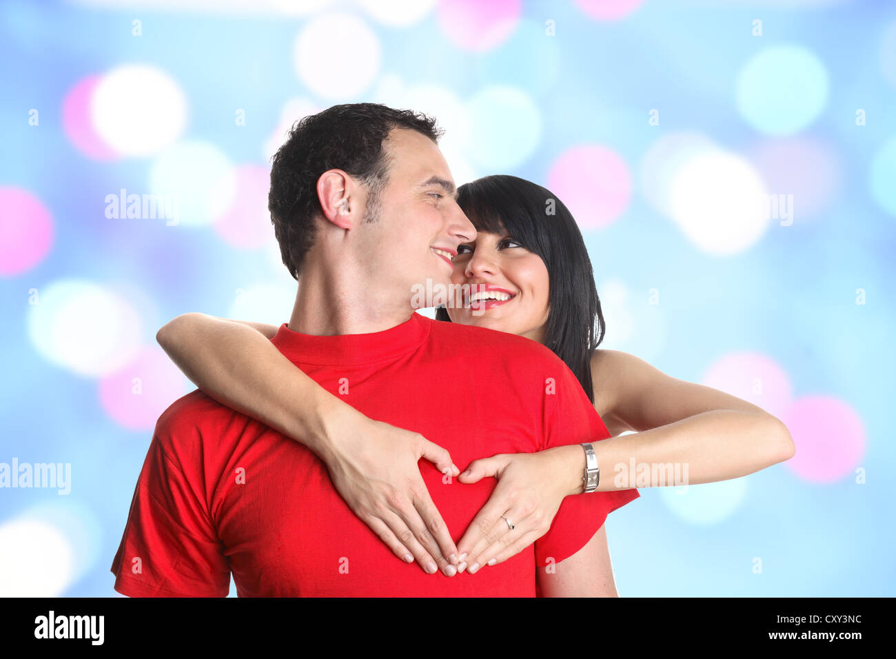 Coppia giovane abbracciando e formando una a forma di cuore gesti con le mani Foto Stock