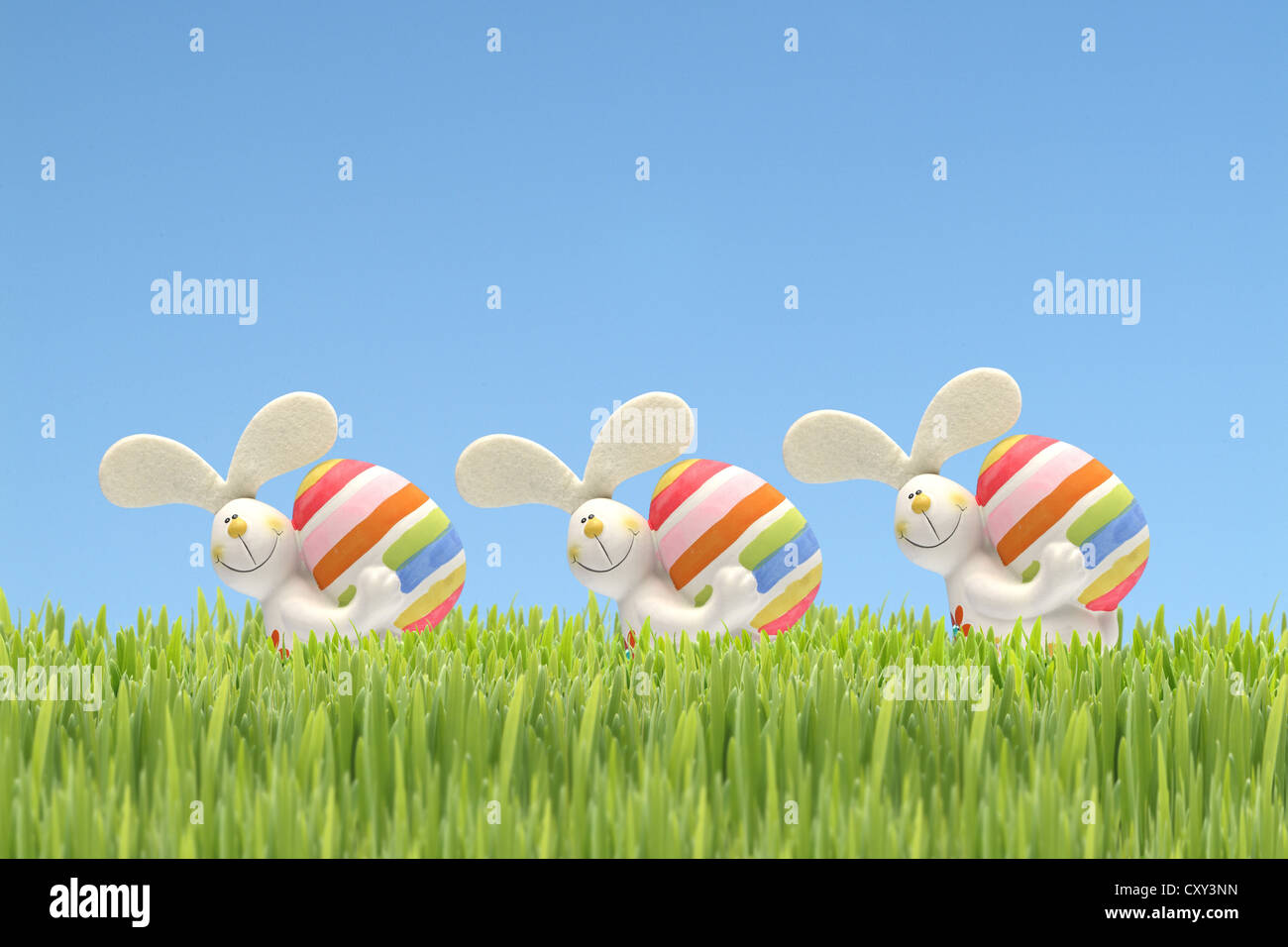 Conigli pasquali che trasportano le uova di Pasqua in erba, illustrazione Foto Stock