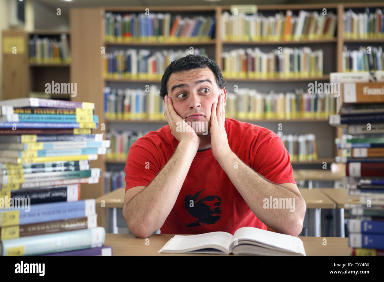 Studente che sta cercando riflessivo in una biblioteca universitaria Foto Stock