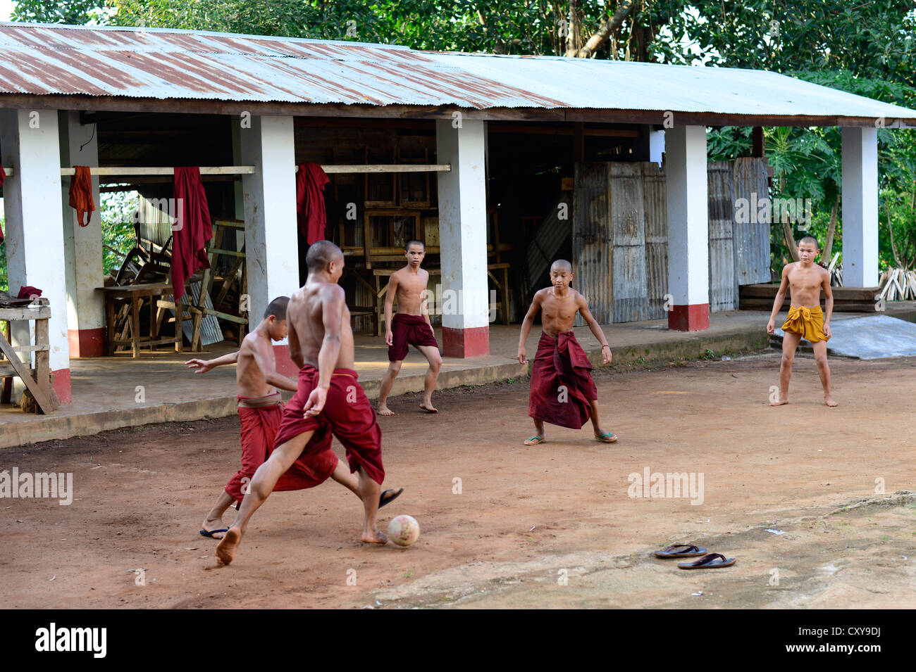 I monaci buddisti che giocano a calcio in un monastero in Myanmar. Foto Stock