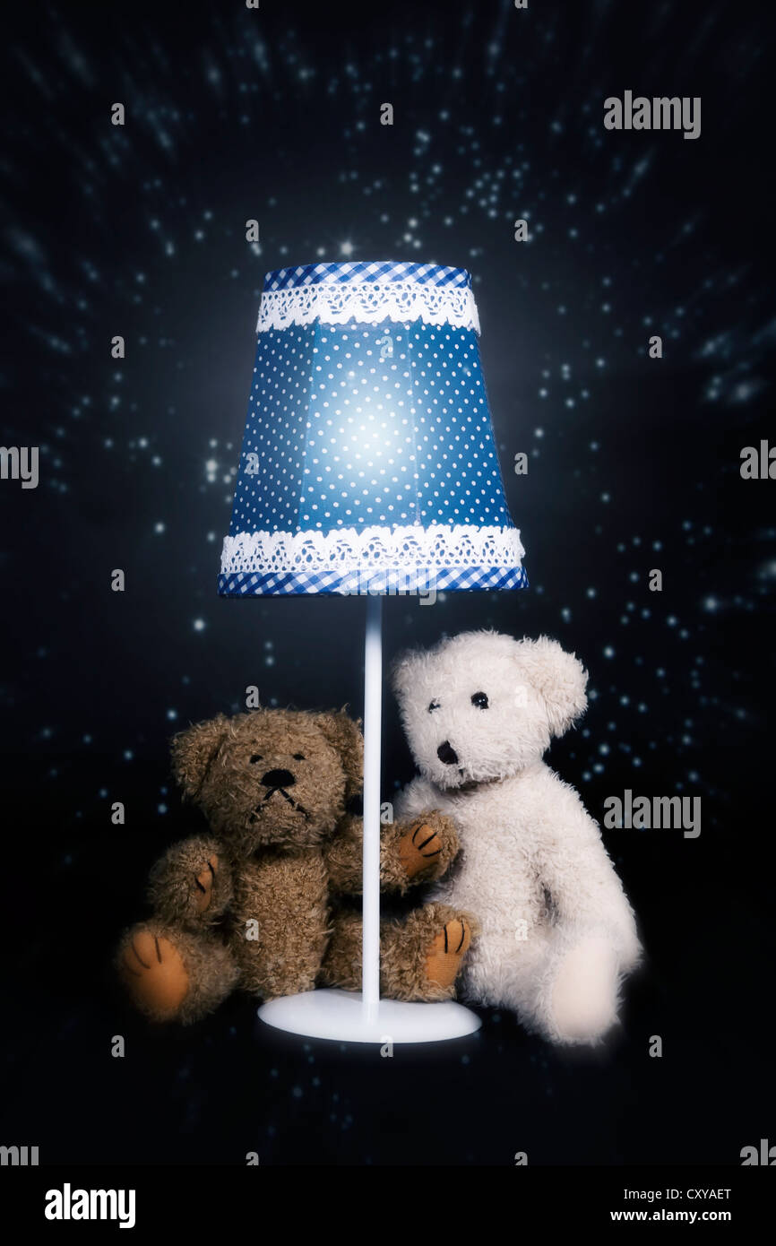 Due orsacchiotti sono seduto sotto una vecchia lampada vintage Foto Stock