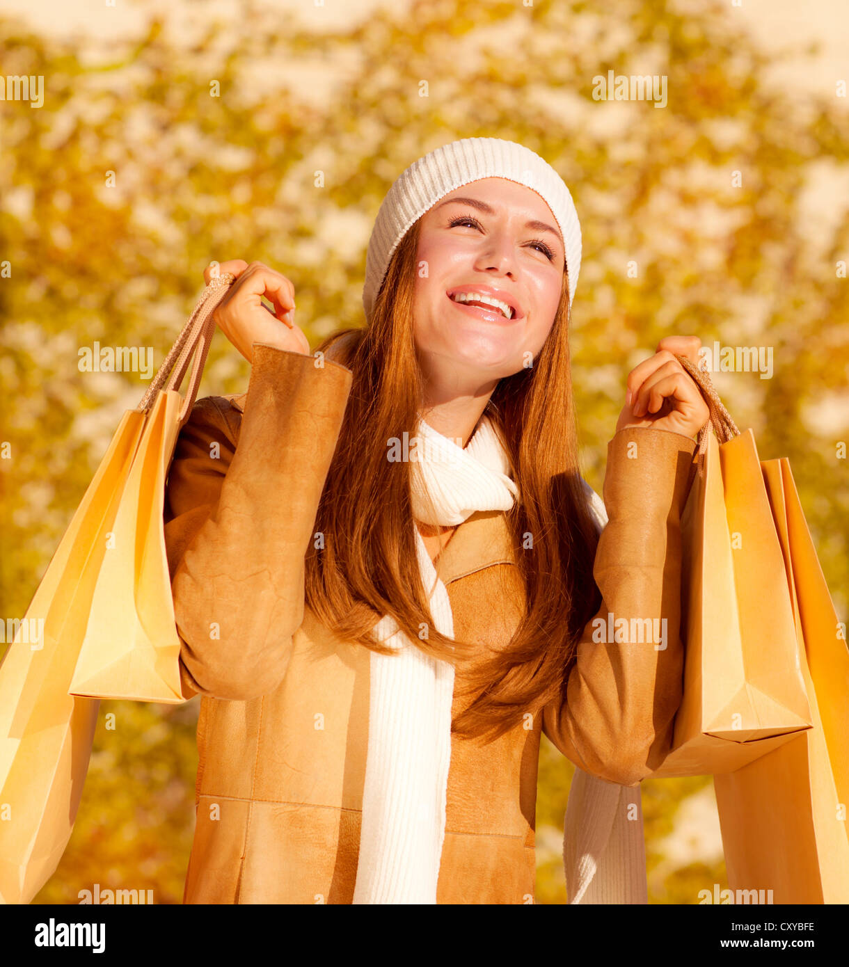 Foto di carino allegro ragazza con le borse della spesa, attraente donna elegante gioire la sua presenta borse, bella femmina in autunno Foto Stock