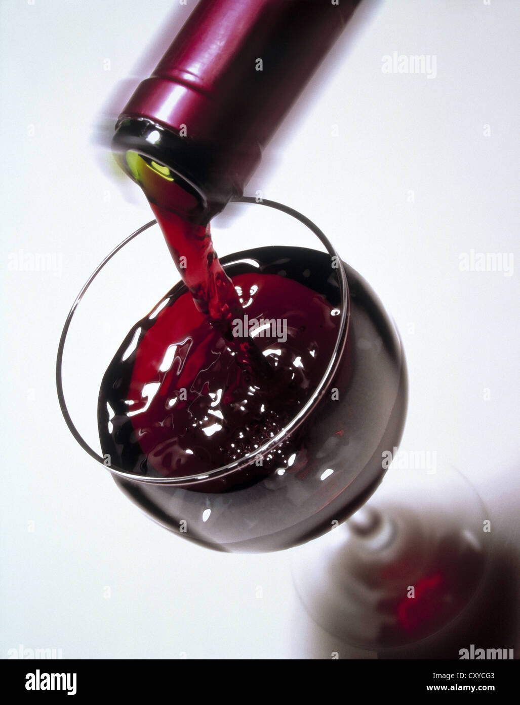 Vino rosso che viene versato in un bicchiere, bottiglia Foto Stock