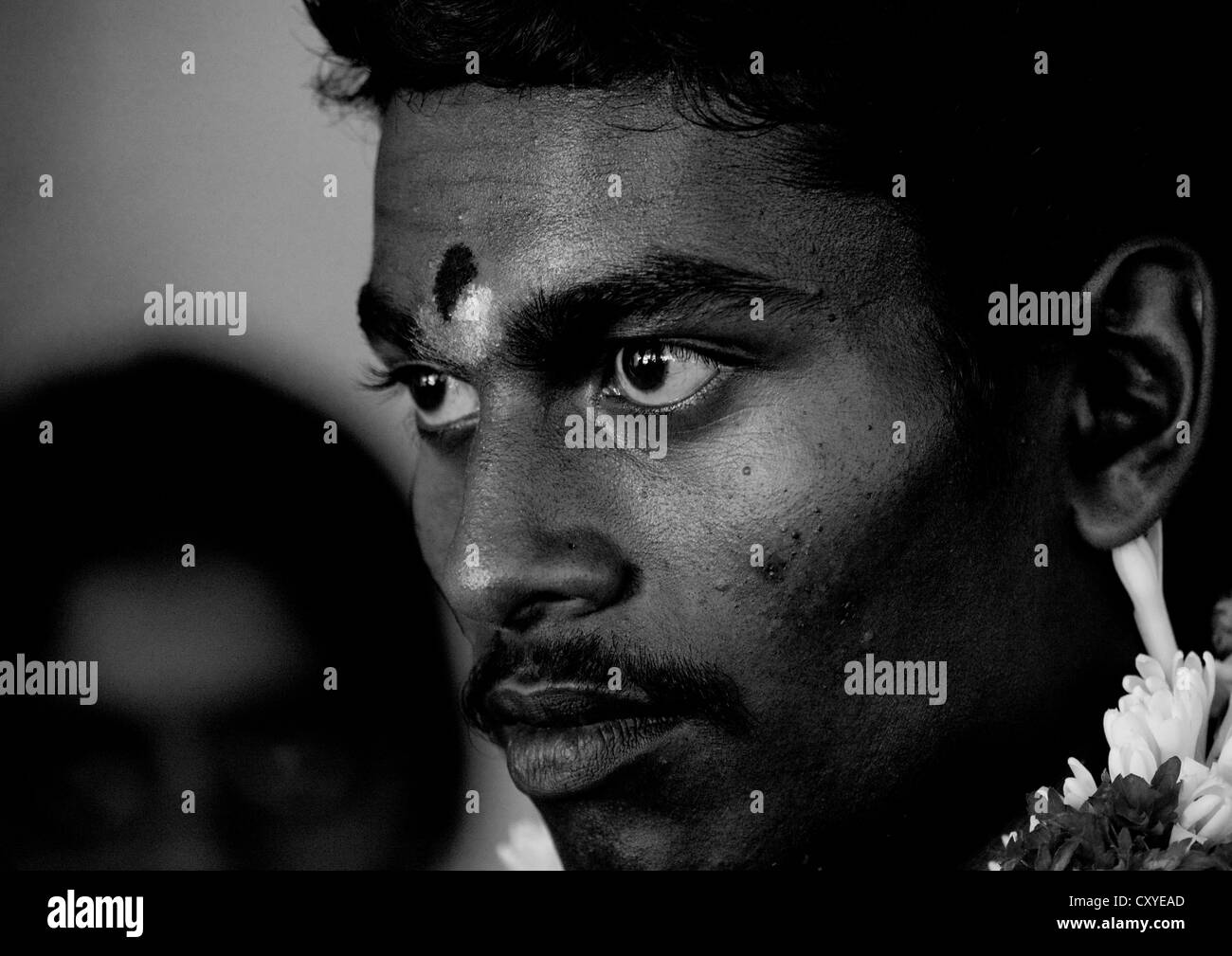 I giovani lo sposo con la pittura tradizionale sulla sua fronte guardando lontano Awy con la concentrazione durante il matrimonio, Trichy, India Foto Stock