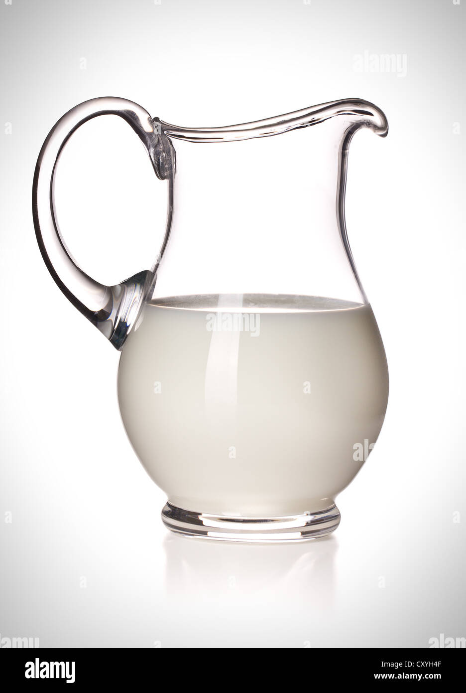 Latte in una brocca di vetro su sfondo bianco Foto Stock