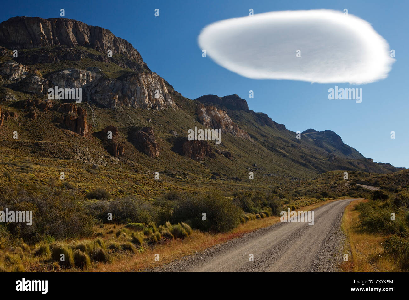 Strada sterrata per Cochrane nella luce della sera sotto un grande bianco cumulus cloud, Altocumulus lenticularis, Rio Chacabuco, Cochrane Foto Stock