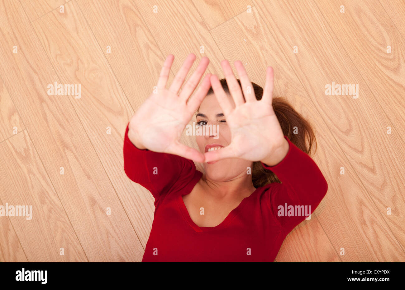 Bella Donna che gioca con la sua ​​hands e guardando alla fotocamera Foto Stock