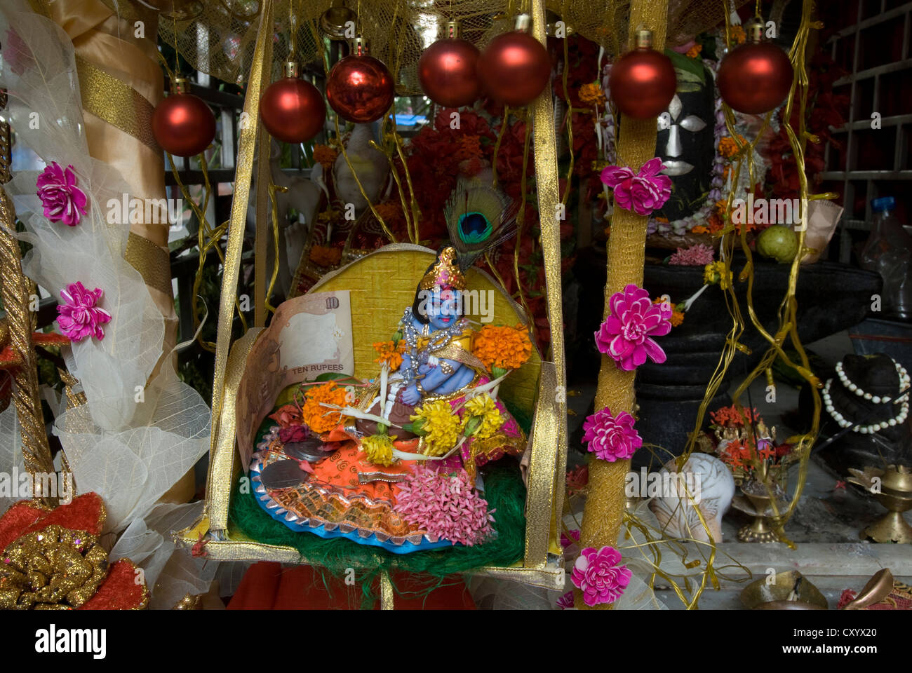 Una piccola statuetta degli Indù Avatar Krishna adorna di un santuario dedicato a Shiva in Kolkata, India Foto Stock