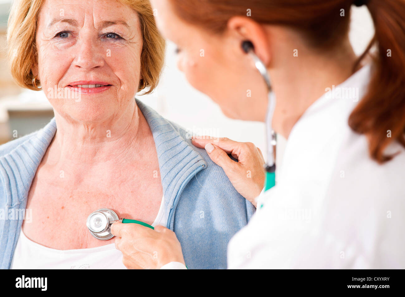 Paziente monitorato dal suo medico di famiglia con uno stetoscopio Foto Stock