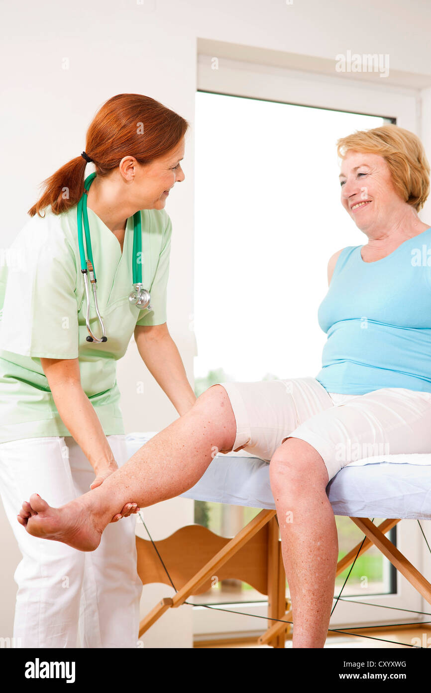 Chirurgo ortopedico esaminando il ginocchio di un paziente Foto Stock