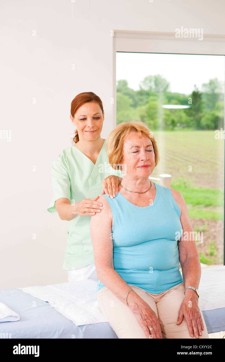 Paziente che viene trattato sulla sua spalla da un fisioterapista Foto Stock