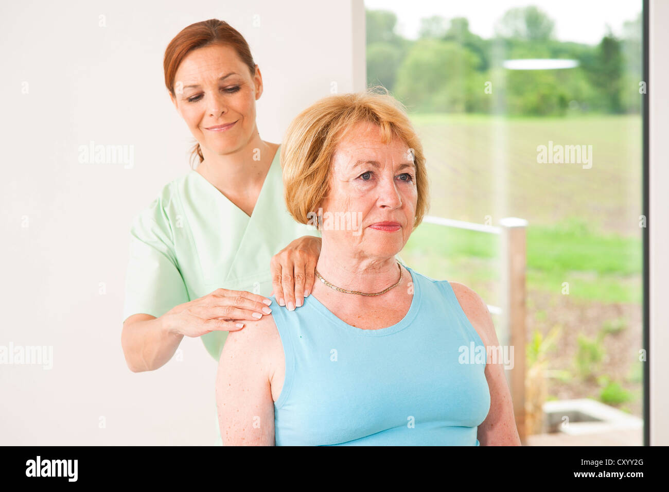 Paziente che viene trattato sulla sua spalla da un fisioterapista Foto Stock