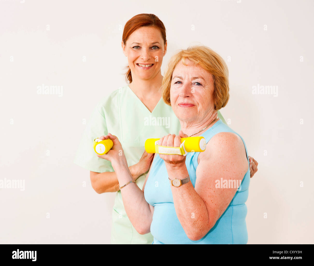 Paziente facendo terapia fisica con manubri in un fisioterapista in pratica Foto Stock