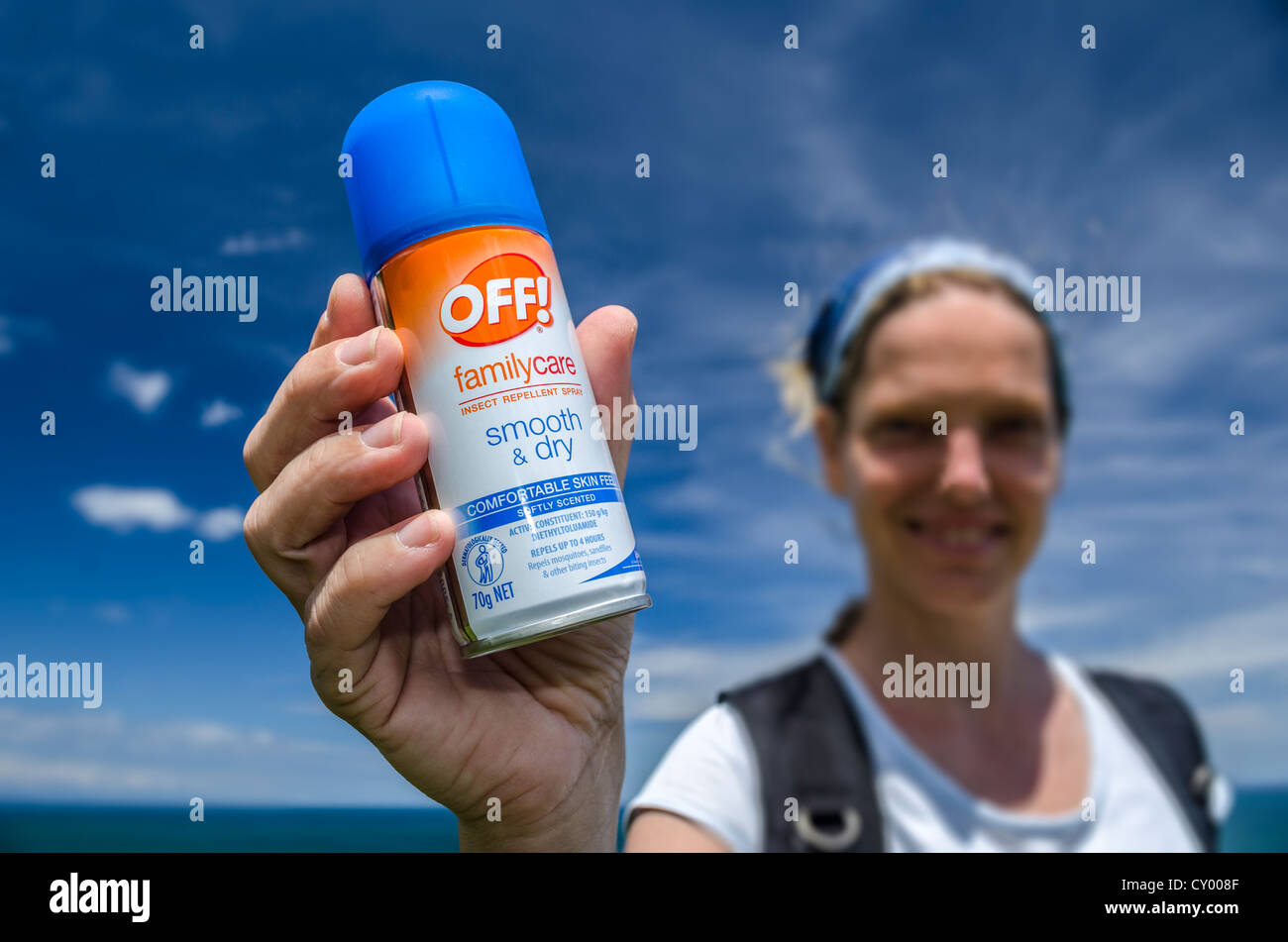 Giovane donna tenendo un può di repellente per insetti in mano, Nuova Zelanda, Oceania Foto Stock