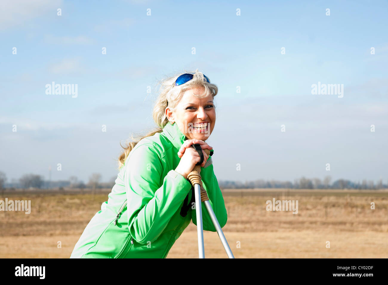 Donna sorridente facendo Nordic walking Foto Stock