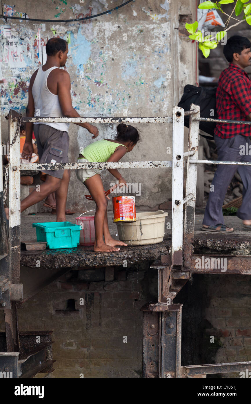Ragazza facendo Servizio lavanderia sulle rive del fiume in Kolkata, India Foto Stock