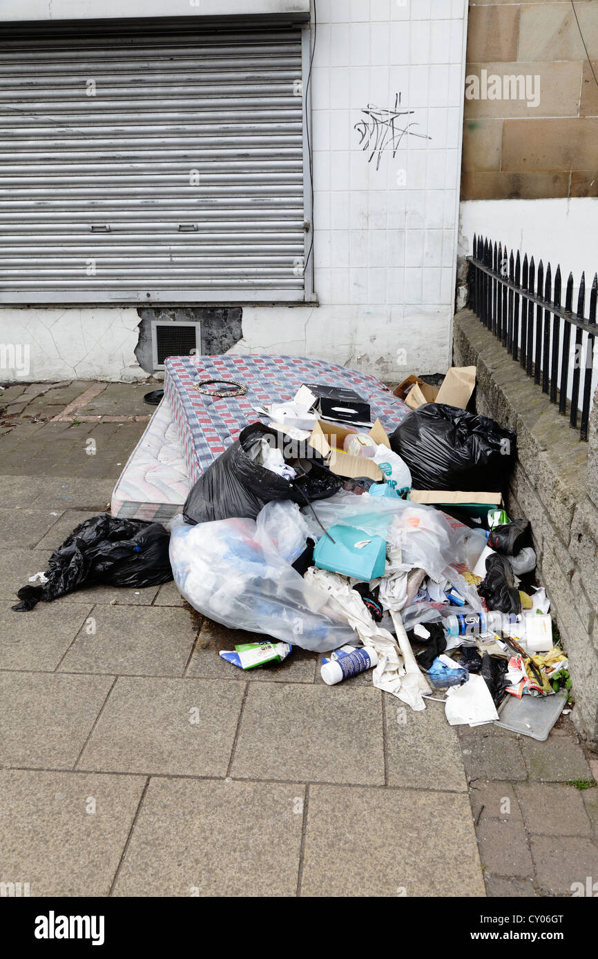 Un materasso e altri articoli per la casa scartati su una strada di Glasgow in Scozia, Regno Unito Foto Stock