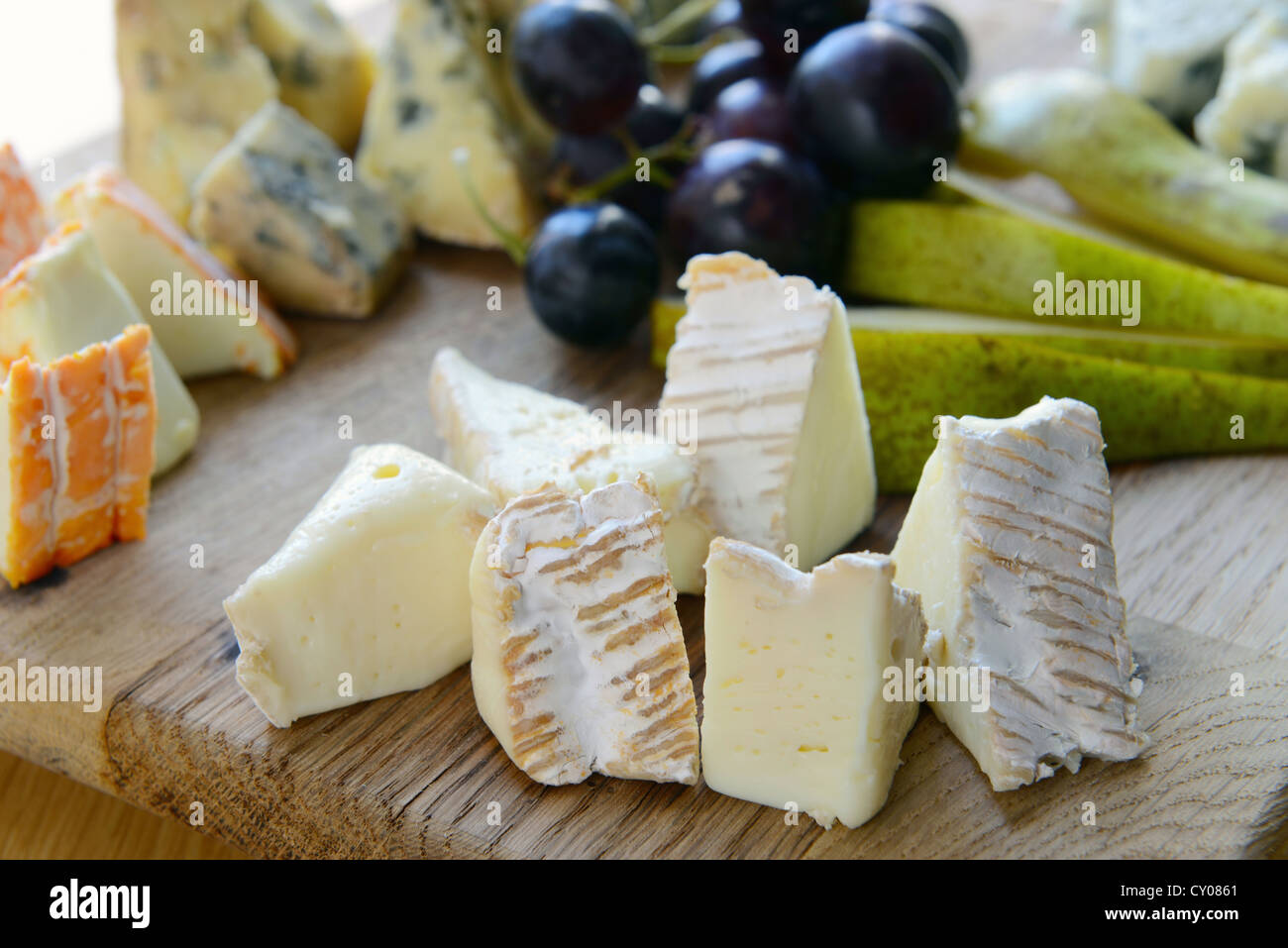 Set di formaggio con stampo su una tavola di legno con uva e pere Foto Stock
