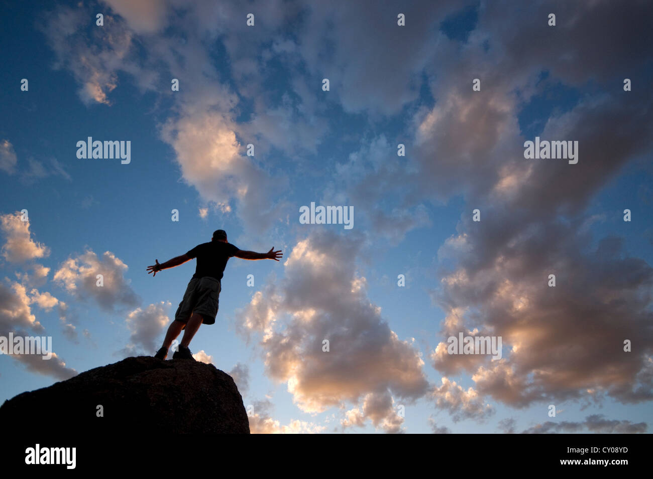 Figura maschile stagliano contro il cielo al tramonto Foto Stock