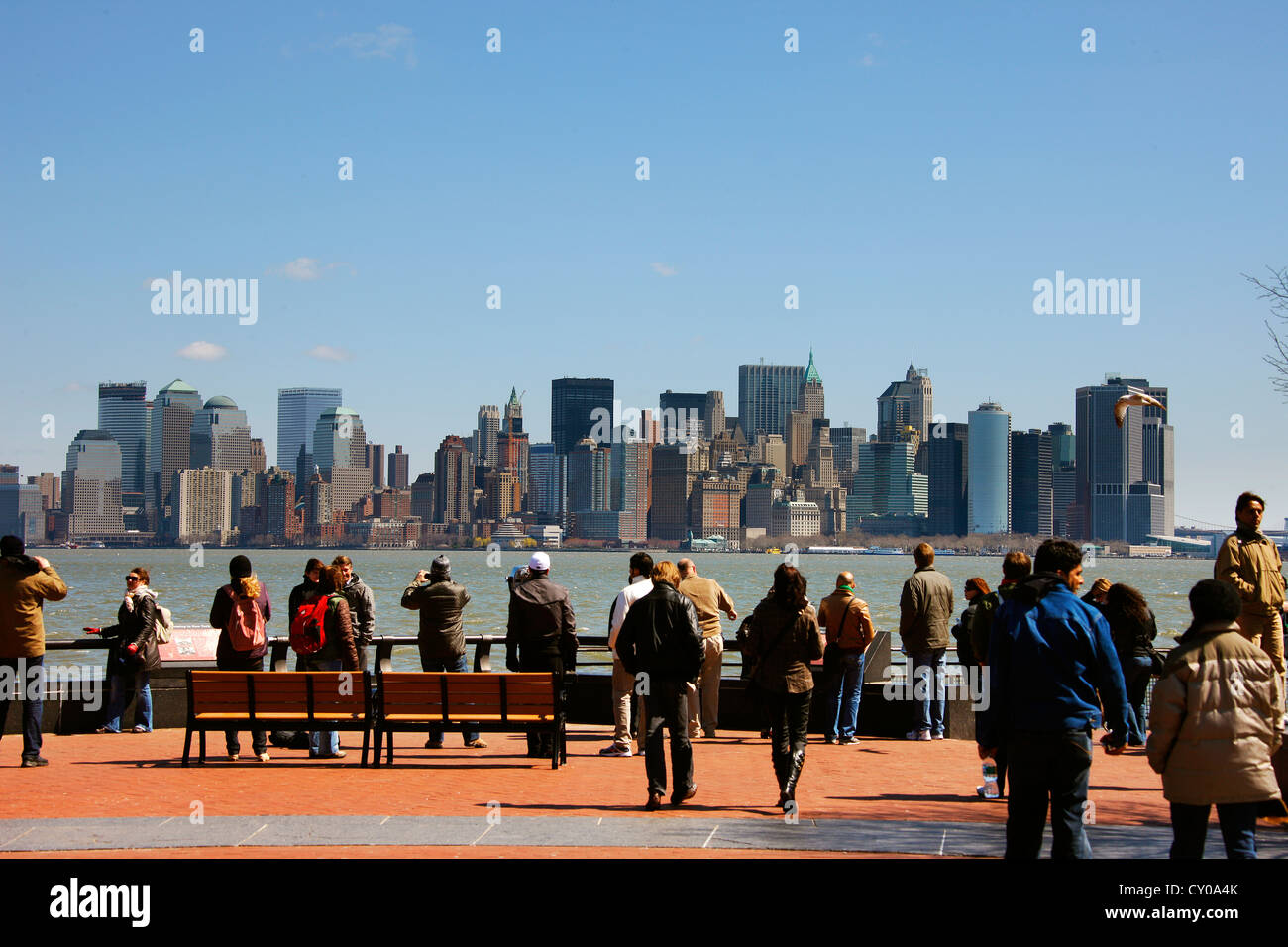I turisti a Liberty Island contro lo sfondo dello skyline della città di New York, New York, Stati Uniti, America del Nord Foto Stock