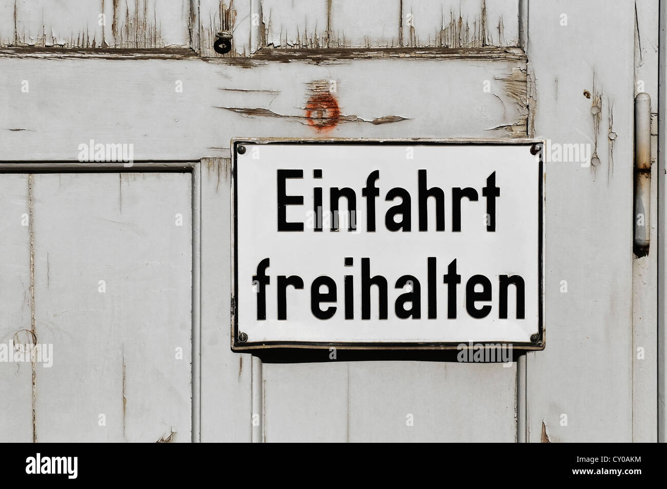 Segno di scritte "Einfahrt freihalten', tedesco per "tenere il passo carraio chiaro', su una vecchia porta di legno, PublicGround Foto Stock