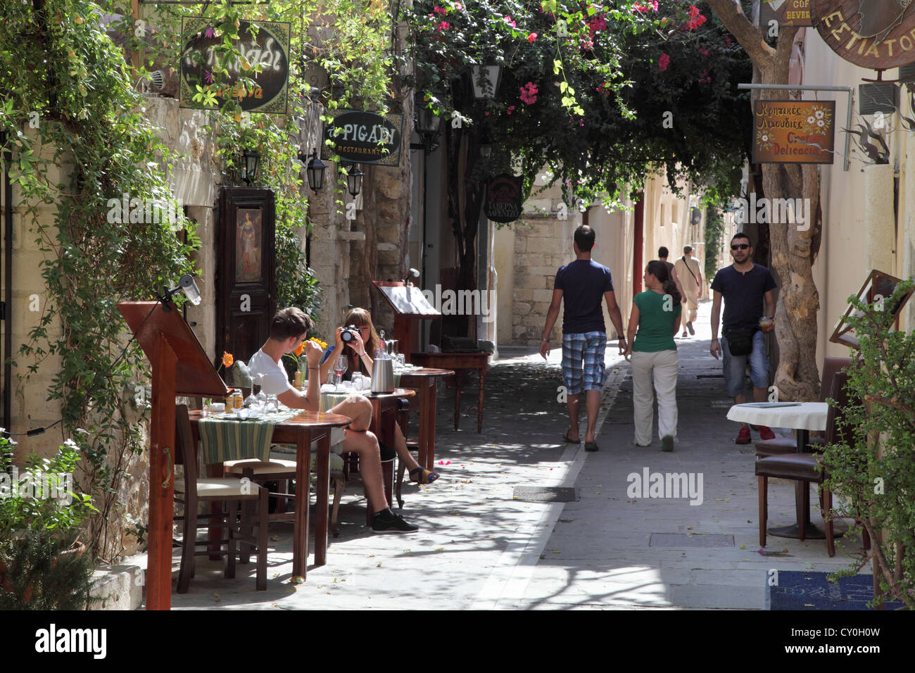 Coppie di mangiare a piedi la città vecchia di Rethymnon, Creta, Grecia Foto Stock