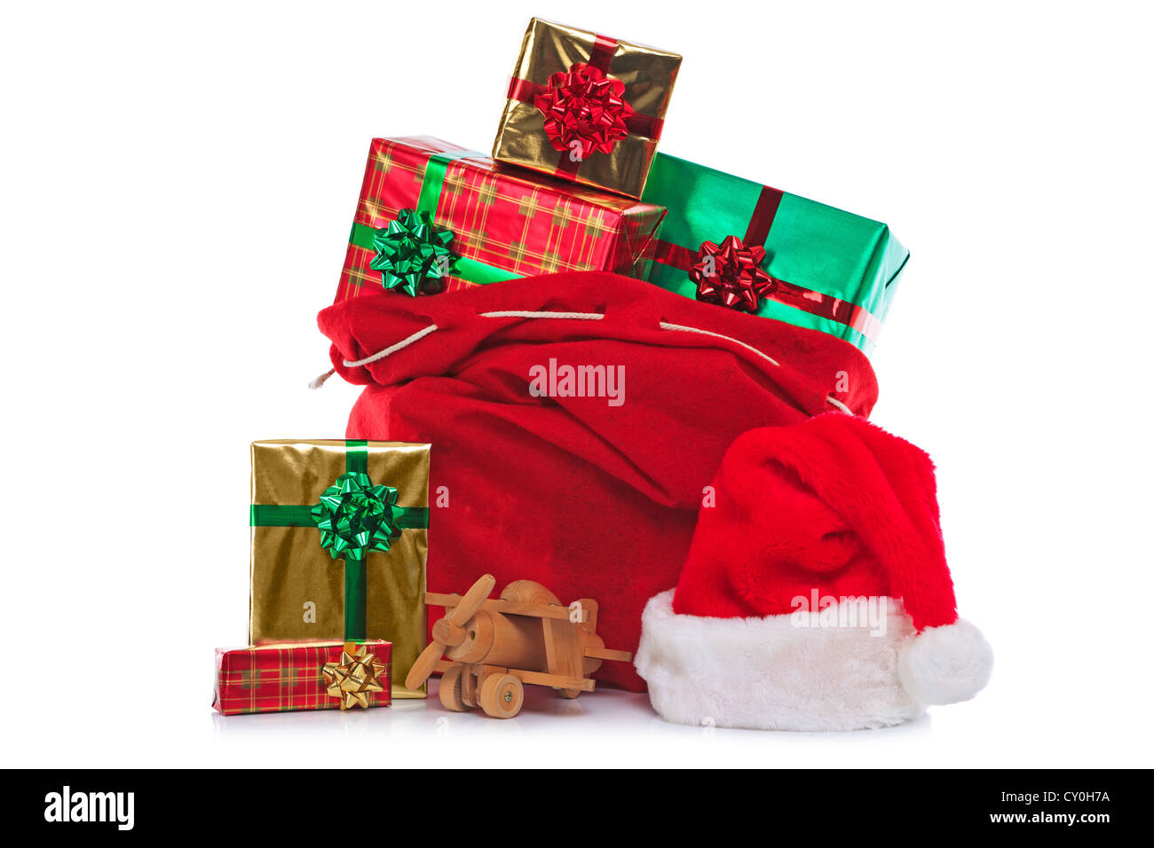Foto di un rosso Berretto di Babbo Natale e il sacco pieno di regalo presenta e giocattoli, isolato su uno sfondo bianco. Foto Stock