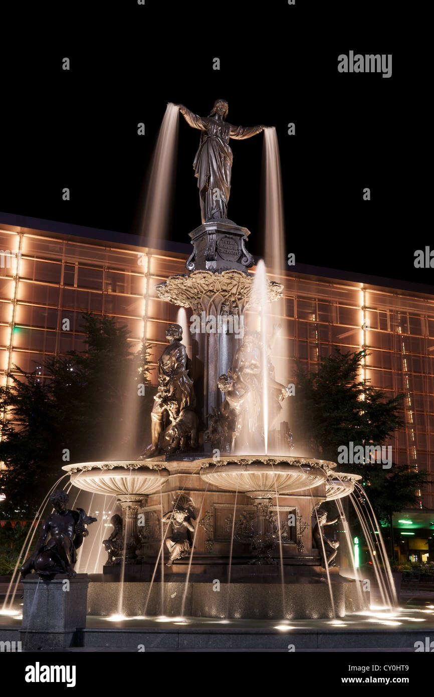 Il Genius di acqua statua in Piazza Fontana, Cincinnati a notte con palazzo arancione Foto Stock