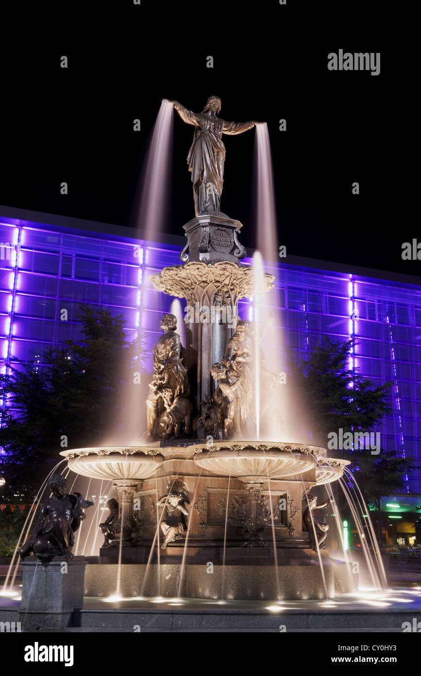 Il Genius di acqua statua in Piazza Fontana, Cincinnati a notte con edificio blu Foto Stock