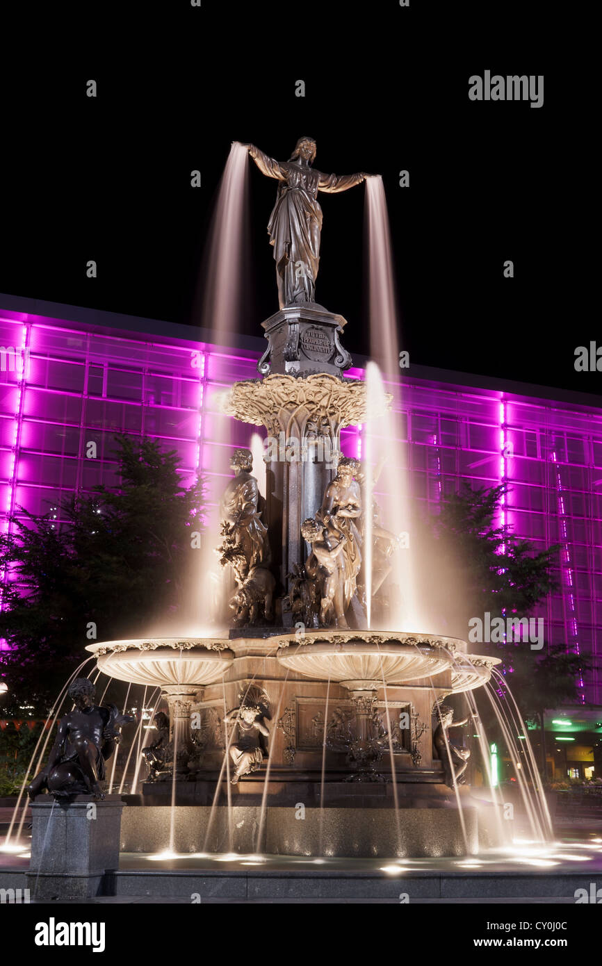 Il Genius di acqua statua in Piazza Fontana, Cincinnati di notte con edificio viola Foto Stock