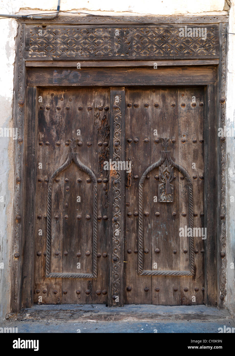Porta in legno intagliato in arabo Stytle di una vecchia casa in Mirbat, Oman Foto Stock