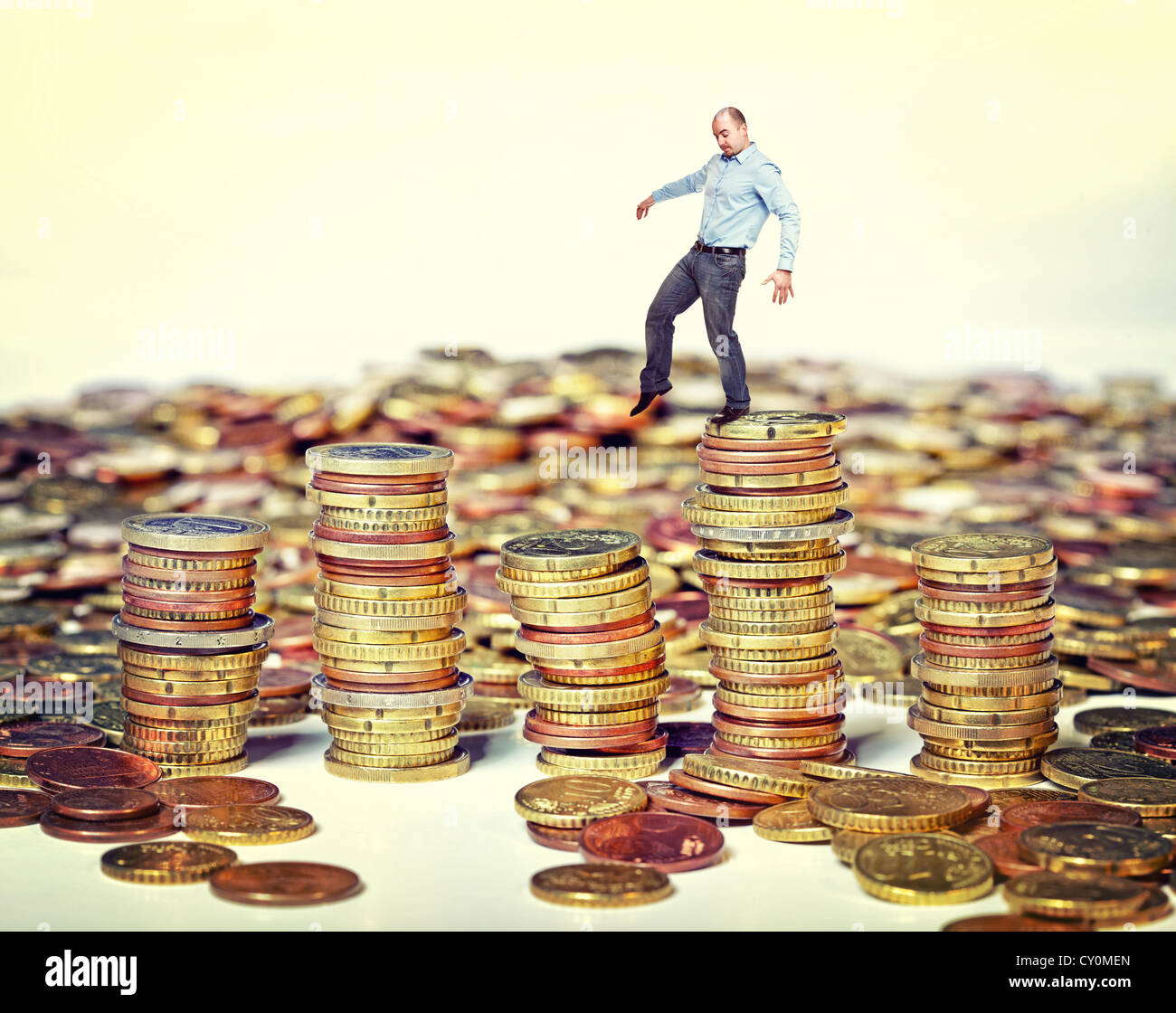 Imprenditore a piedi sulla moneta in euro di pile Foto Stock