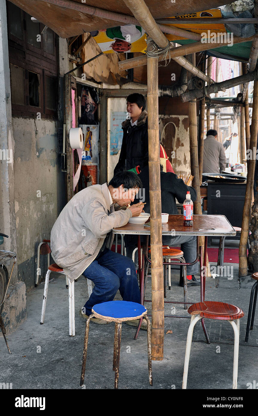 Uomo cinese di mangiare nel ristorante di strada a Shanghai old town (Nanshi distretto) - Cina Foto Stock