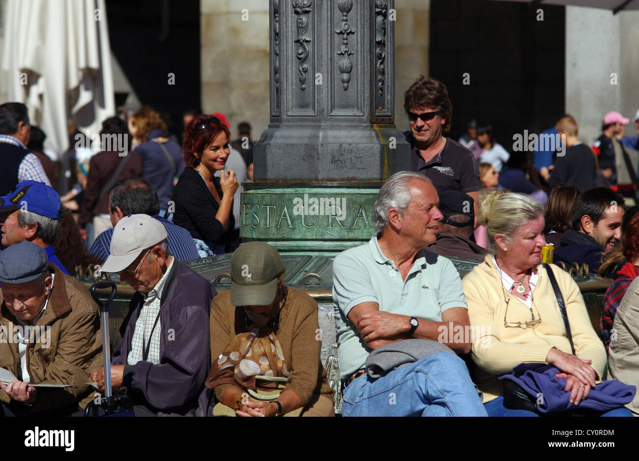 Turisti e residenti godendo il sole in Plaza Mayor, Madrid Foto Stock